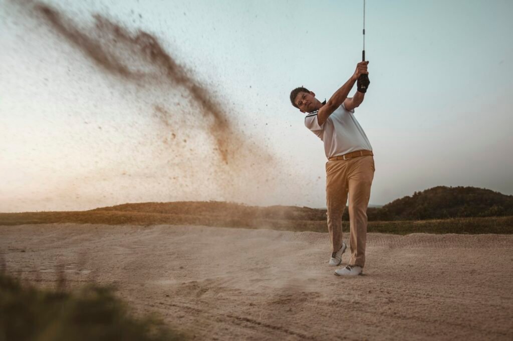 lifestyle, golf, activity, sport, golfer concept A man is sweeping golf on the sand