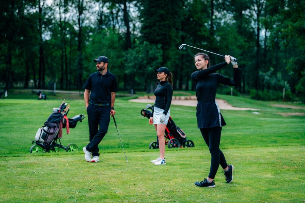 Playing golf. Young woman playing golf with golf instructor